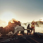Firefighters responding to a car crash at sunset.