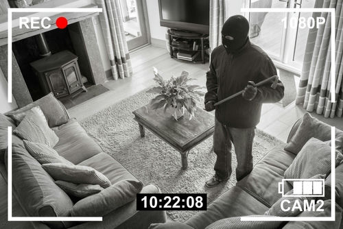 shutterstock2159524295-1jpg Home security footage of masked intruder with crowbar.