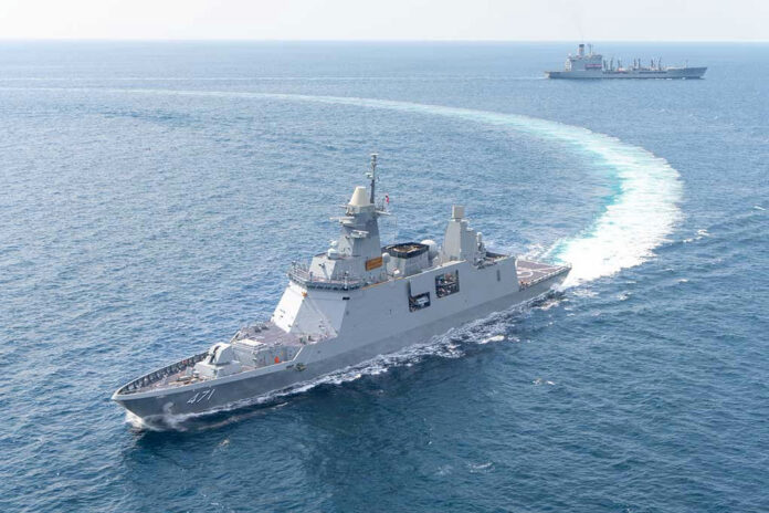 1387024358 Warships maneuvering at sea, leaving a white wake.