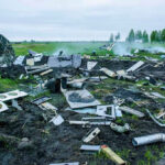 Skydiving Tragedy Stuns Missouri Wreckage of crashed plane scattered across field, smoke rising.