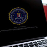 Bank Crackdown Targets Cartel Cash Laptop screen displaying FBI emblem and terminal interface.