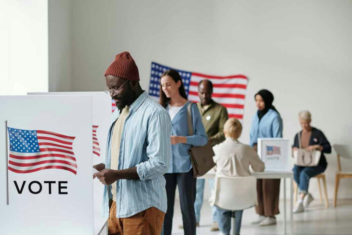 2274349689 People voting in a polling station with American flags.