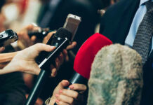 Situation Room Tapes? Aides Panic Interview microphones pointed at a person in suit.