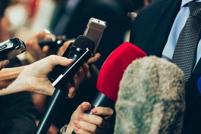 461773729 Interview microphones pointed at a person in suit.