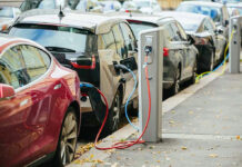 Dealer Panic Torches EV Prices Electric cars charging at street charging stations.