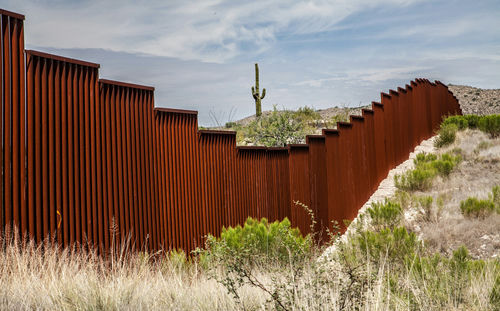 shutterstock459602719jpg rust-colored border fence in a desert landscape