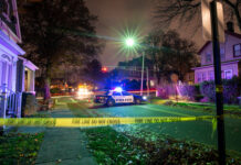 Citywide Lockdown After Montreal Bloodshed Police car with flashing lights at a crime scene surrounded by caution tape
