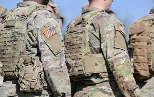 shutterstock_2145891607 Soldiers in camouflage uniforms with American flag patches.