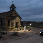 Catholic School Targeted—Arrest Mid-Drive Police and forensic team at a crime scene near an abandoned church in the desert