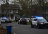 Wealthy Suburb’s First Murder In 10 Years! Police vehicles parked outside a house at dusk.