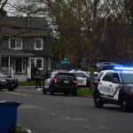Wealthy Suburb’s First Murder In 10 Years! Police vehicles parked outside a house at dusk.