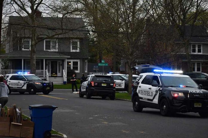 1708467166 Police vehicles parked outside a house at dusk.