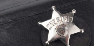 Sheriff badge on black leather surface.
