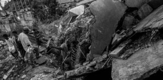 People navigate rubble and collapsed concrete in a disaster scene