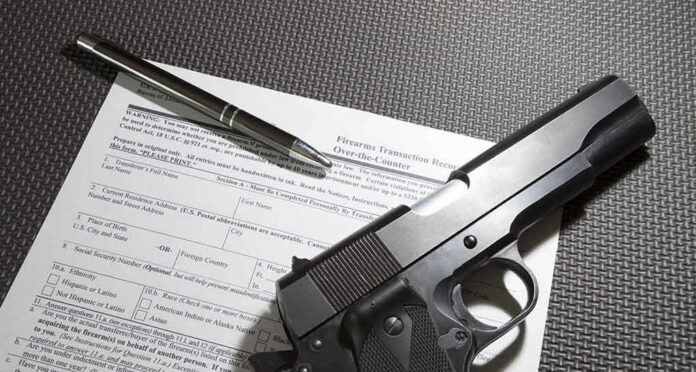581003293 Form with gun and pen on table.