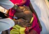 A healthcare professional examining a pregnant woman's abdomen with a stethoscope
