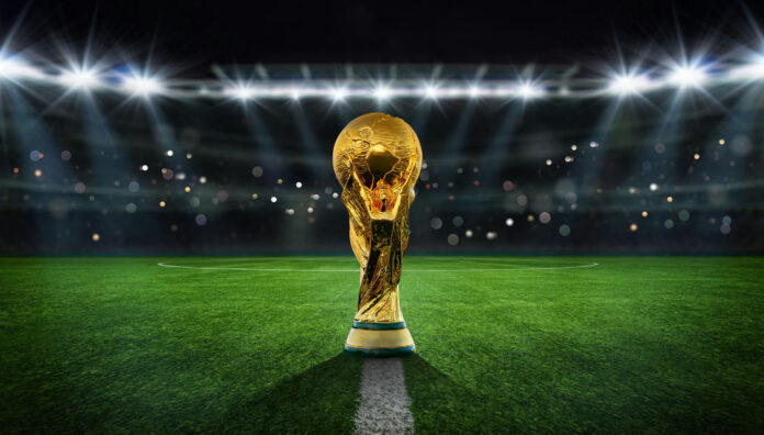 shutterstock2215849493 Golden trophy on soccer field under stadium lights