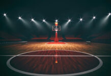 An empty basketball court illuminated by dramatic lighting