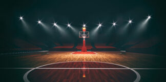 An empty basketball court illuminated by dramatic lighting