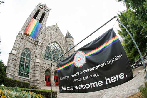 Atlanta,,Gausa,-,October,12,,2019:,A,Gay,Pride,Banner Exterior view of a church with a rainbow flag and an inclusive message banner