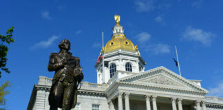 New Hampshire State House with statue in foreground.