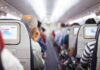 Passengers sitting in airplane seats with screens.