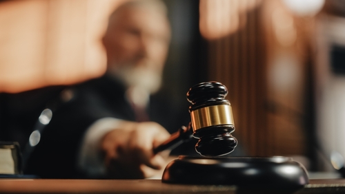 Judge striking gavel in courtroom.