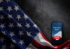 U.S. flag and phone displaying Election Day voting message.